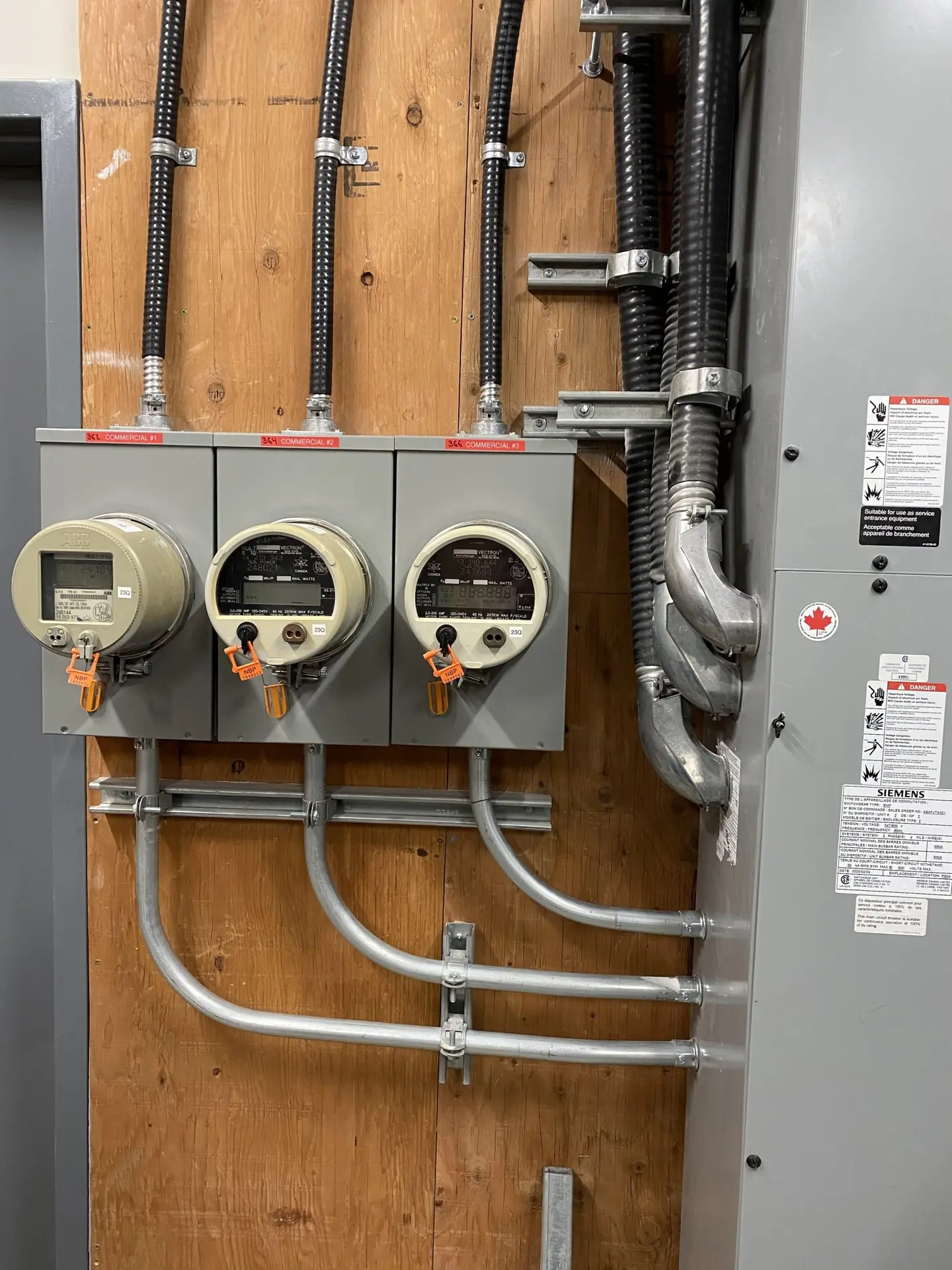 A bank of electrical meters and conduit installed by LuMar Electric