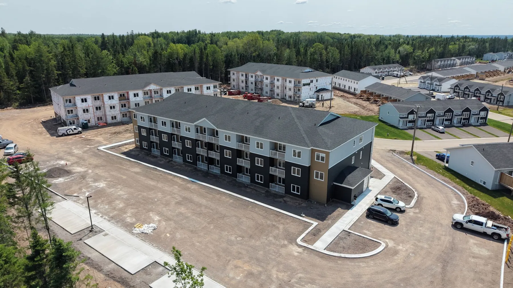 A finished apartment building and its parking lot