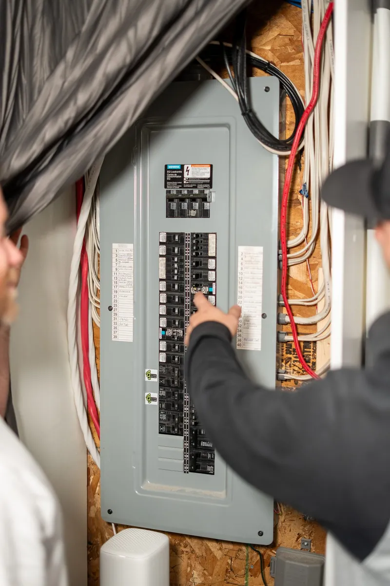 Electrician checking breakers in a residential electrical panel in Moncton