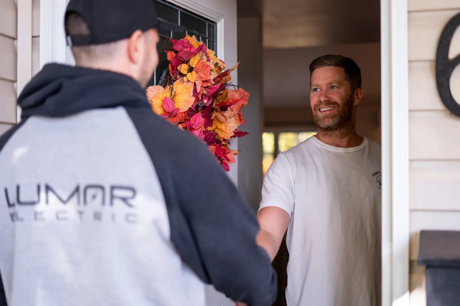 Homeowner greeting a LuMar Electric electrician at the front door