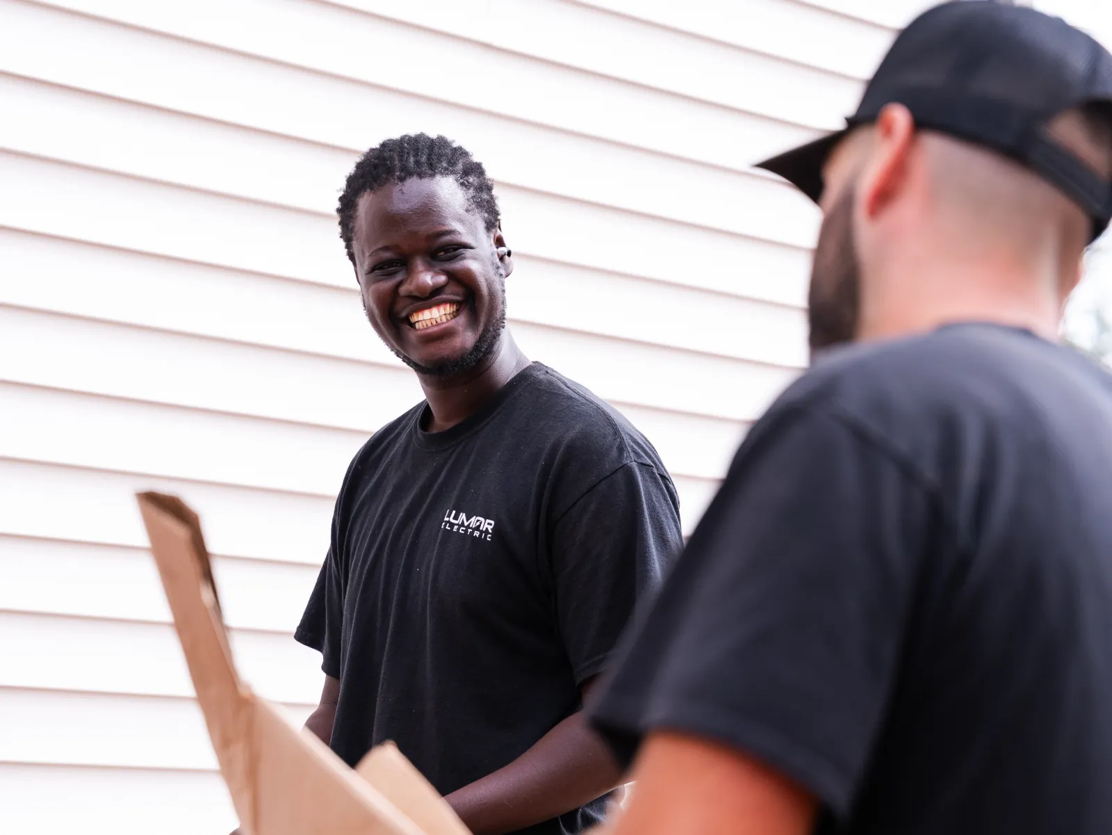 Two members of the LuMar Electric crew sharing a laugh on site