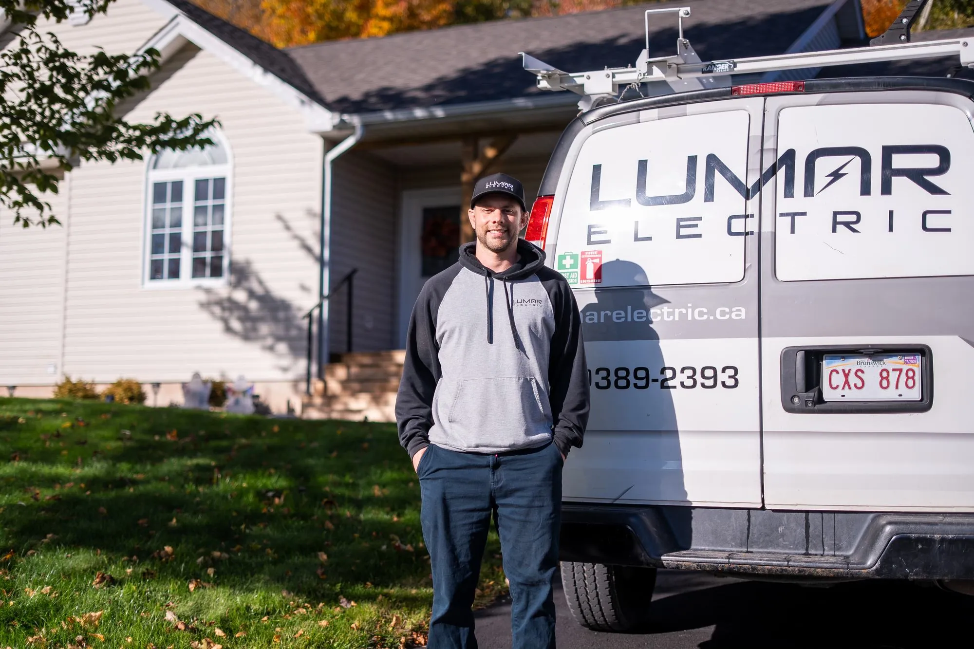 LuMar Electric electrician standing beside his service van outside a customer&rsquo;s home