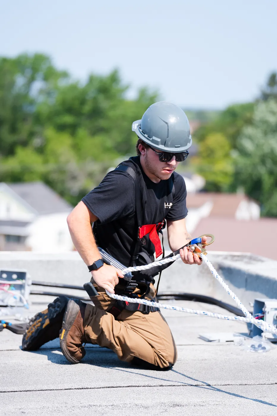 A LuMar Electric electrician in a safety harness working at height