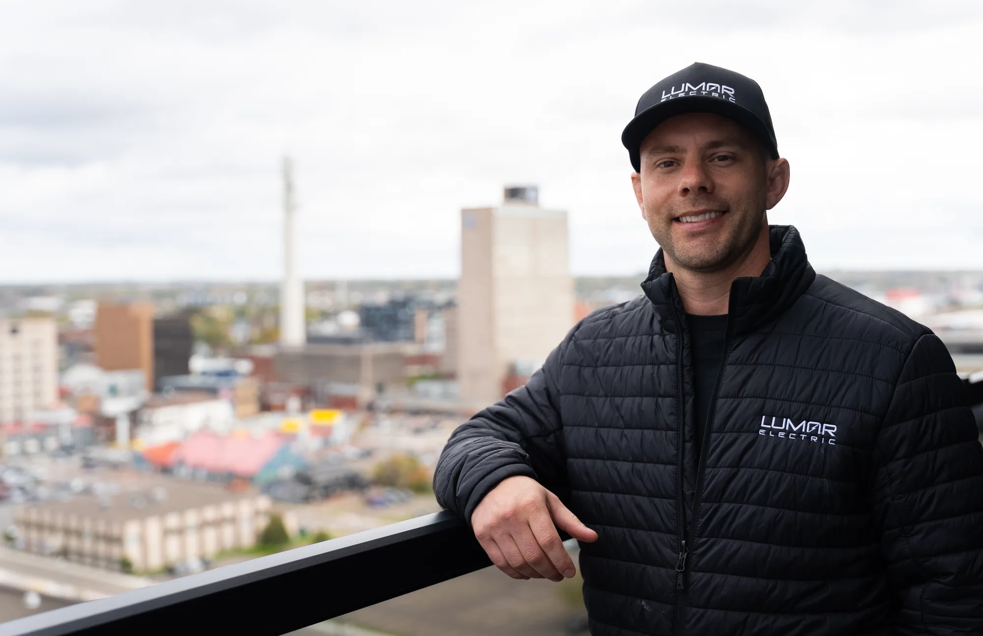 A LuMar Electric team member on a balcony above downtown Moncton
