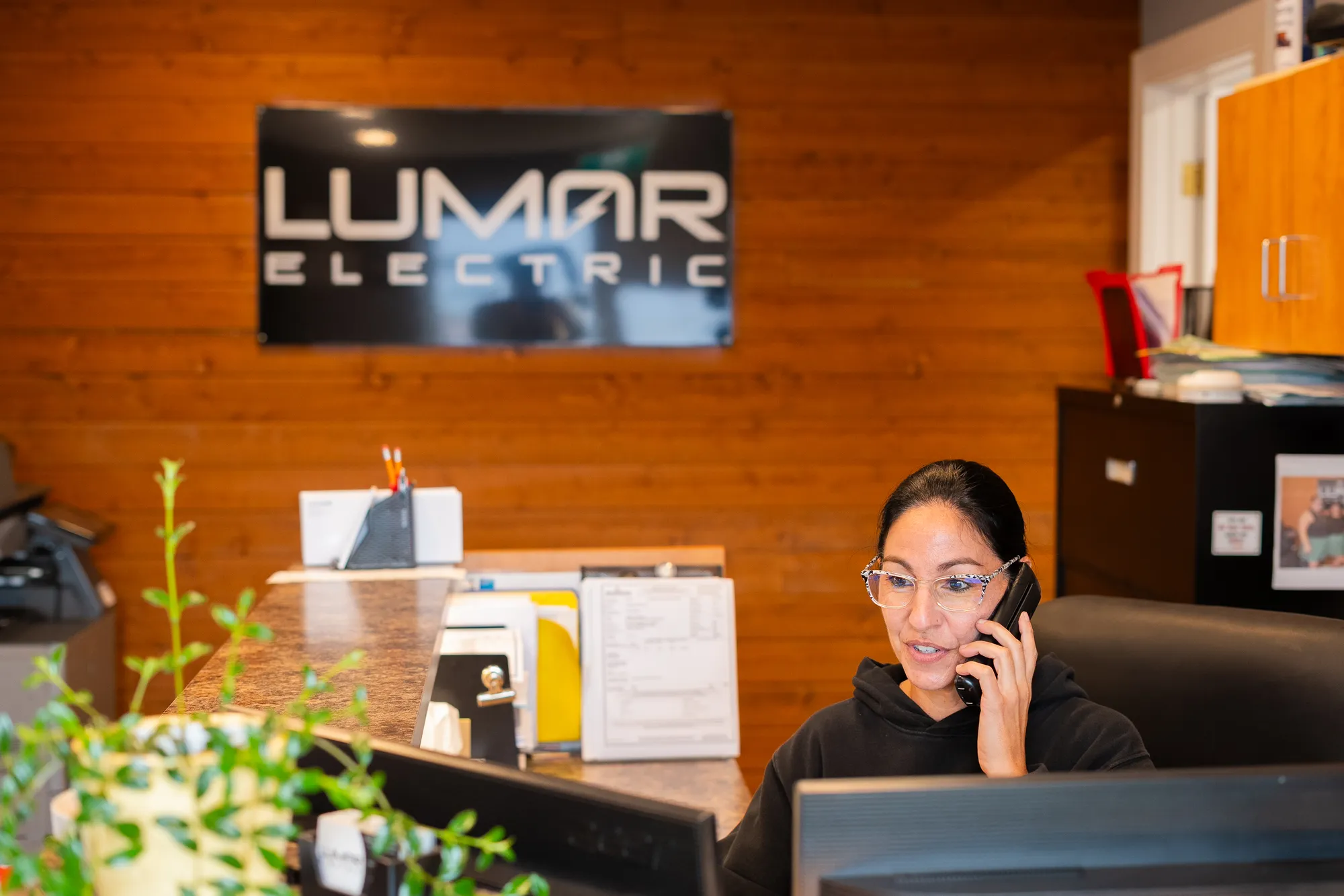 A LuMar Electric team member answering a customer call at the office
