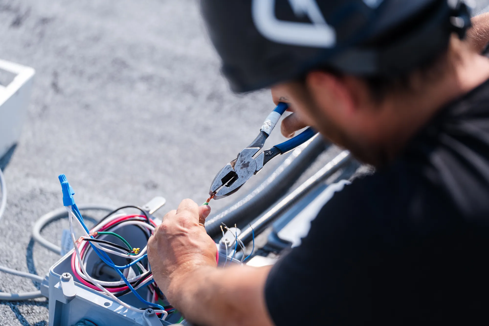 Close-up of a LuMar Electric electrician making up wiring on a rooftop