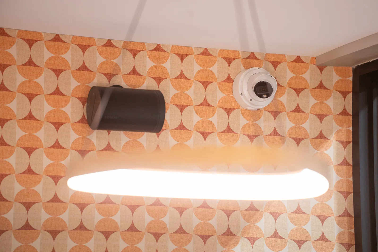 Pendant light, security camera and speaker in the lounge at Rally House