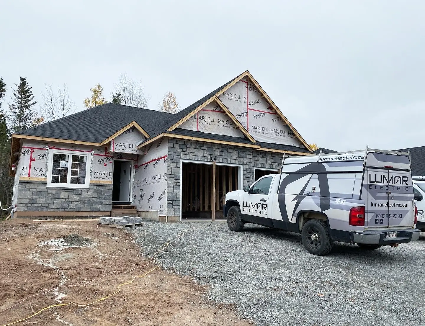 House under construction with electric service truck.