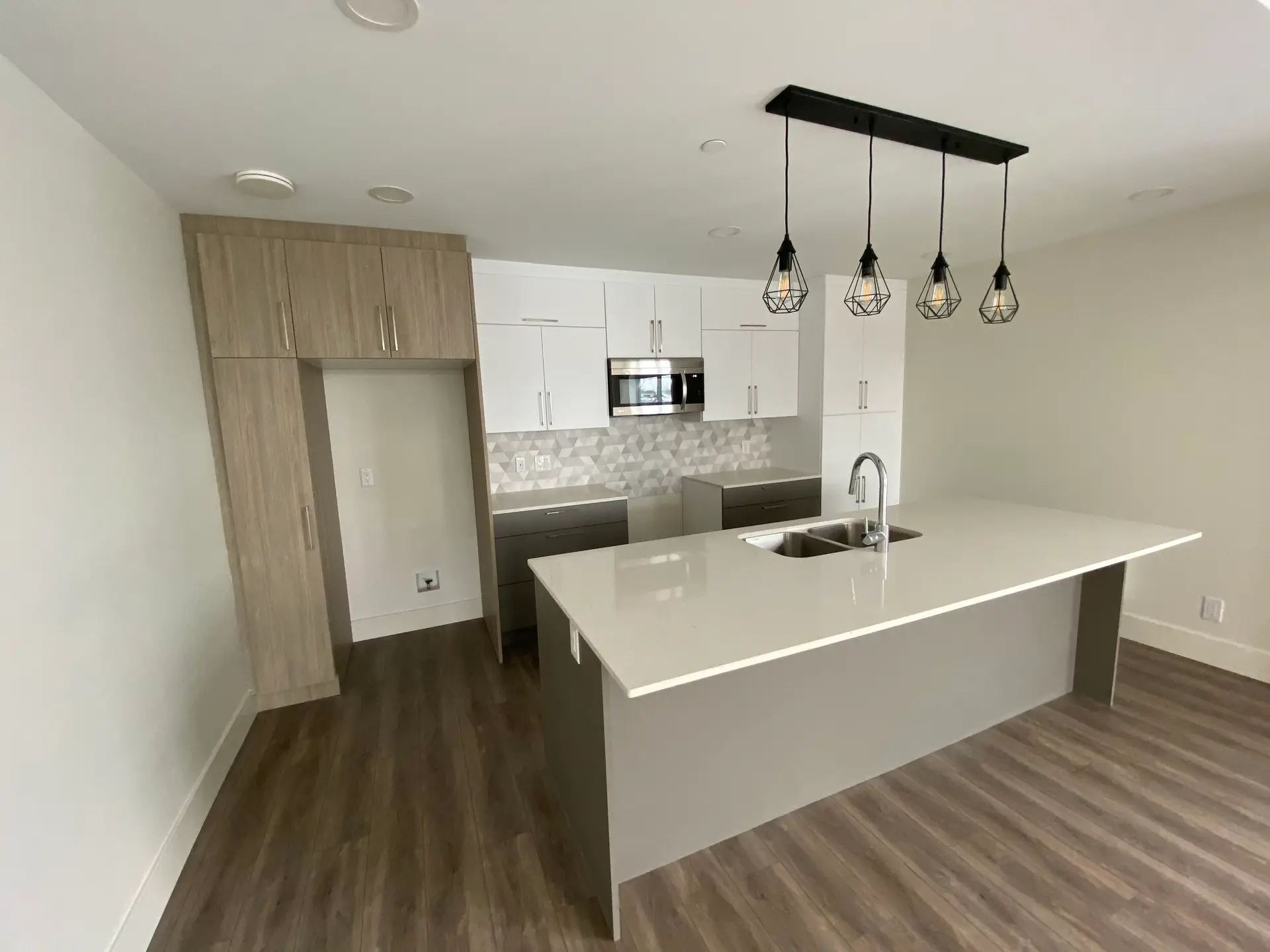 Modern kitchen with island and pendant lights.