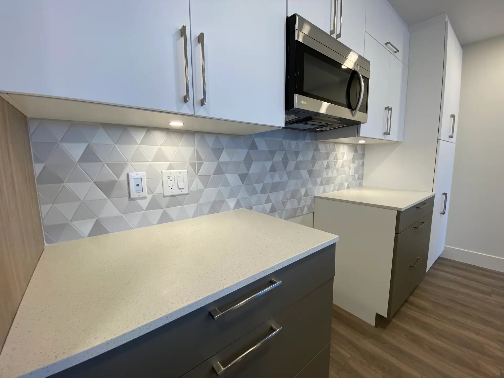 Modern kitchen with geometric tile backsplash.