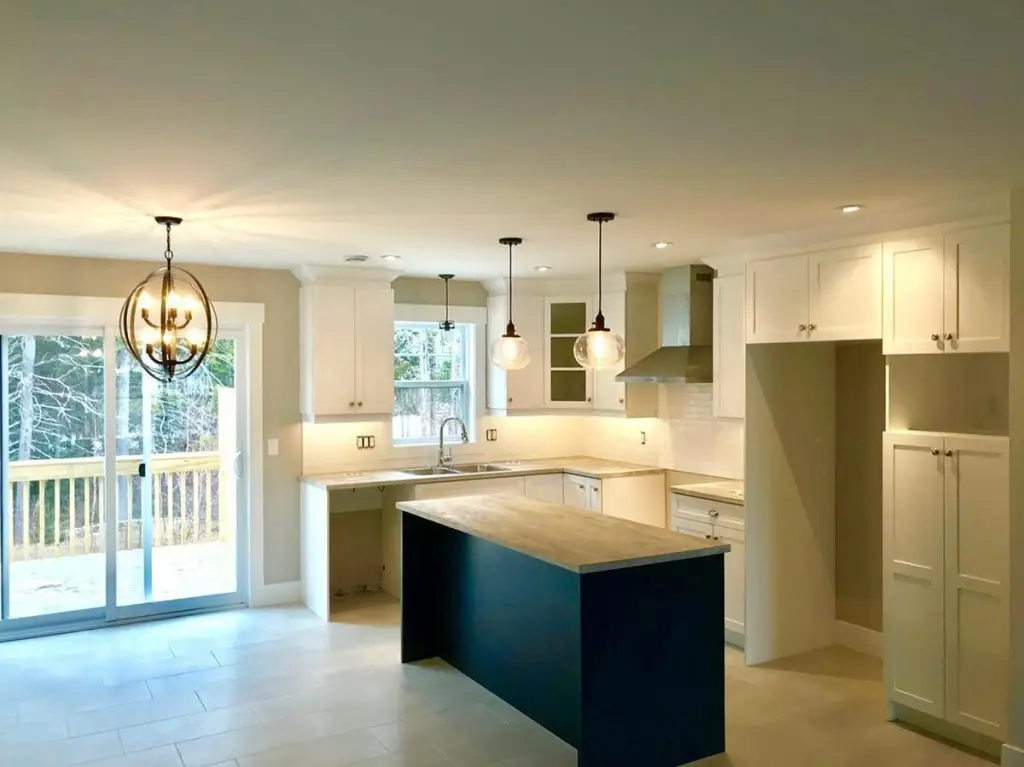 Modern kitchen with island and pendant lights.
