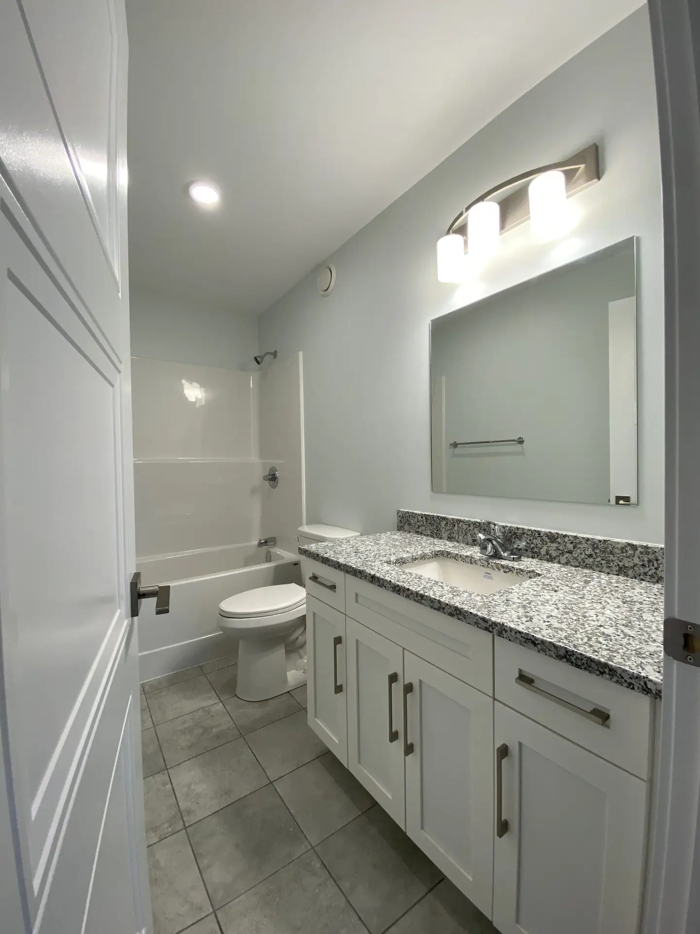 Modern bathroom with tub and granite countertop.